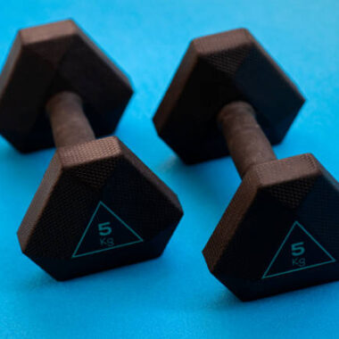 Two black weights 5 kg on the blue background