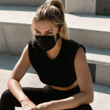 Young athletic woman wearing face mask during summer street workout